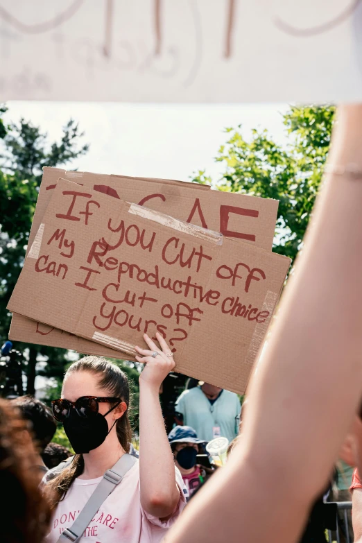 a person holding a sign that reads if you cut off my representative's choice i can cut out more of your