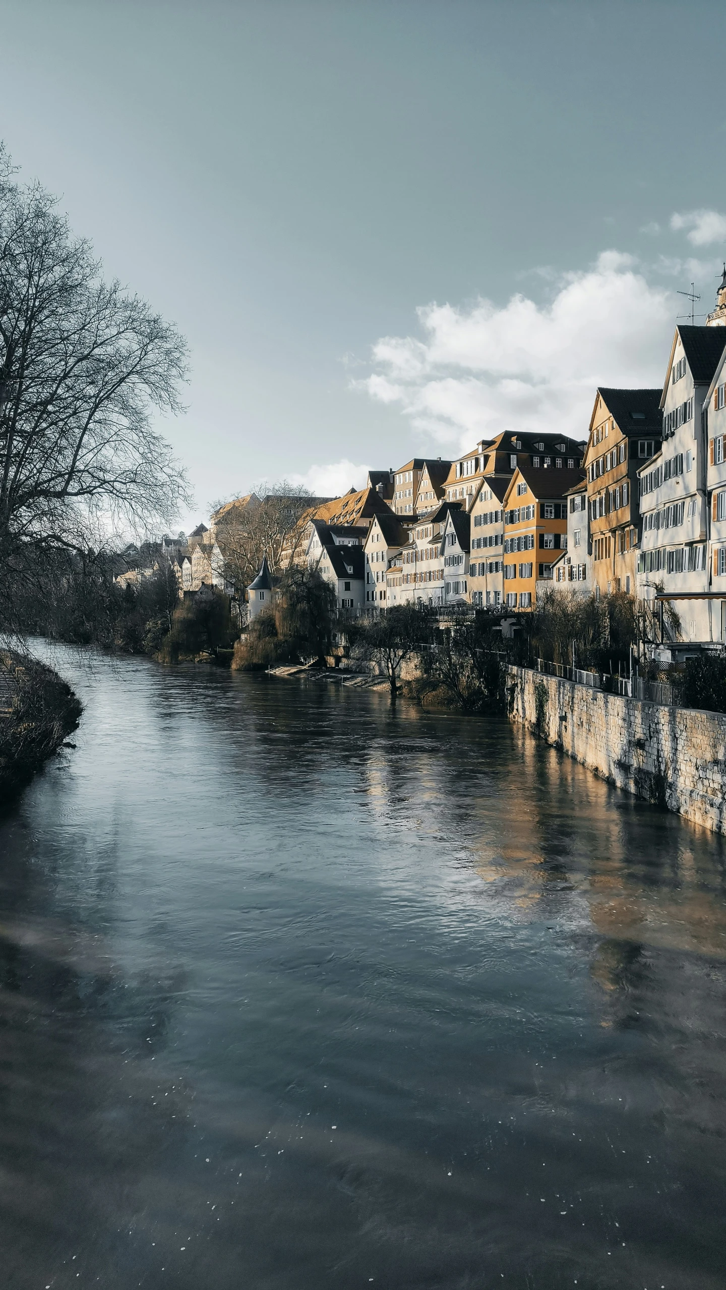 the river runs through an old town as a storm moves in