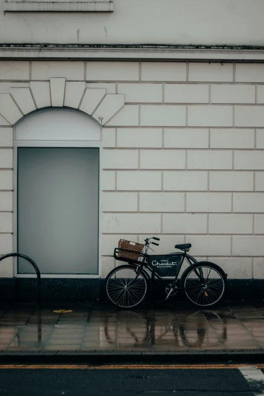 an old bicycle sits outside of an empty doorway