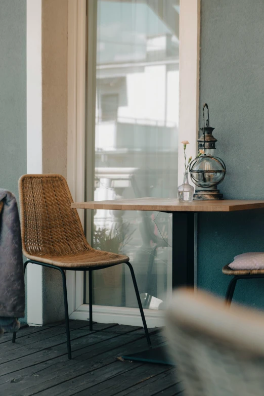 a wicker chair on a wooden floor next to a table