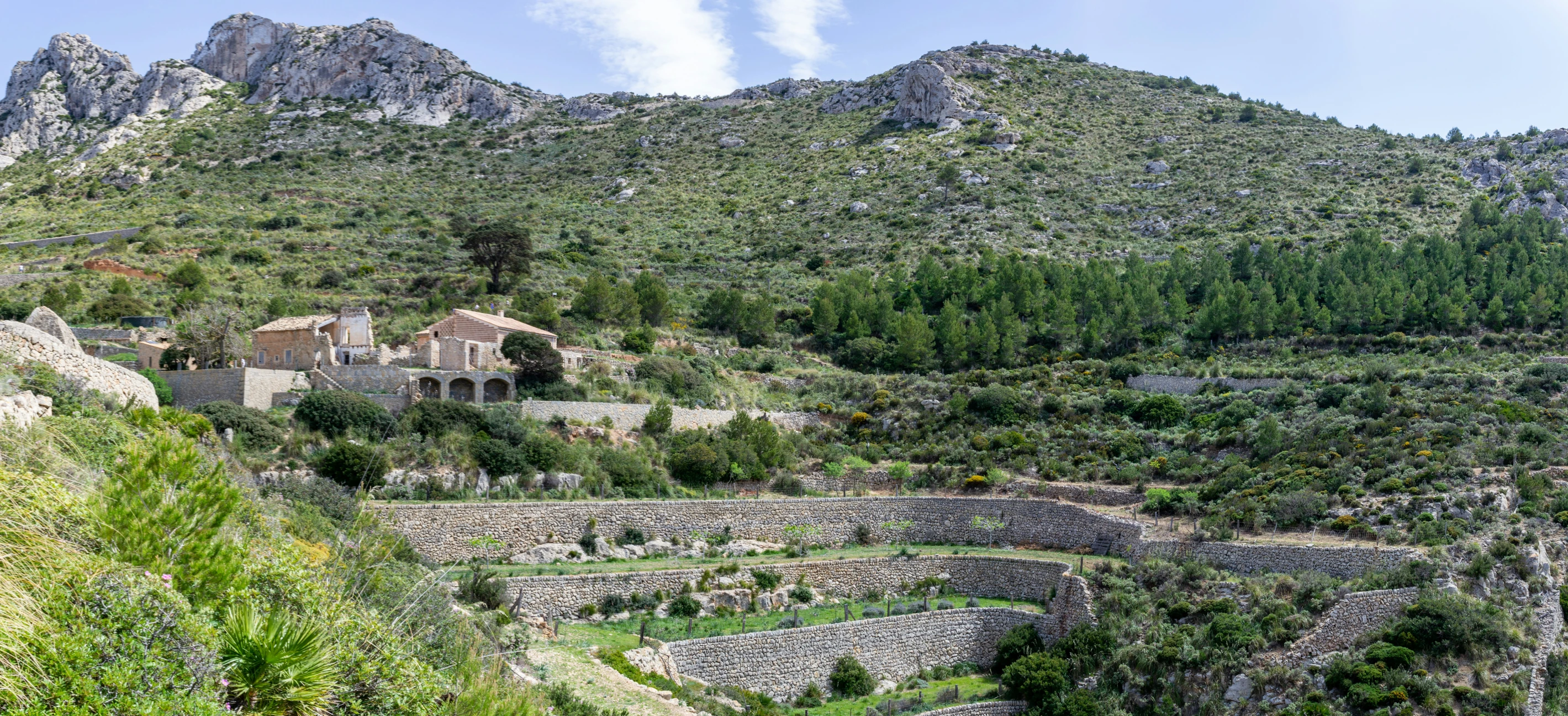 a stone building in a hillside next to trees