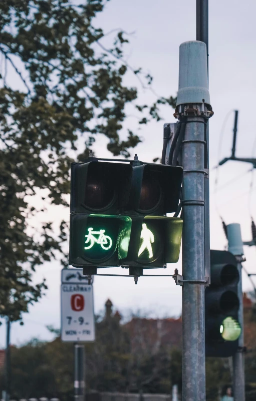 a traffic light with green lights hanging off it's sides