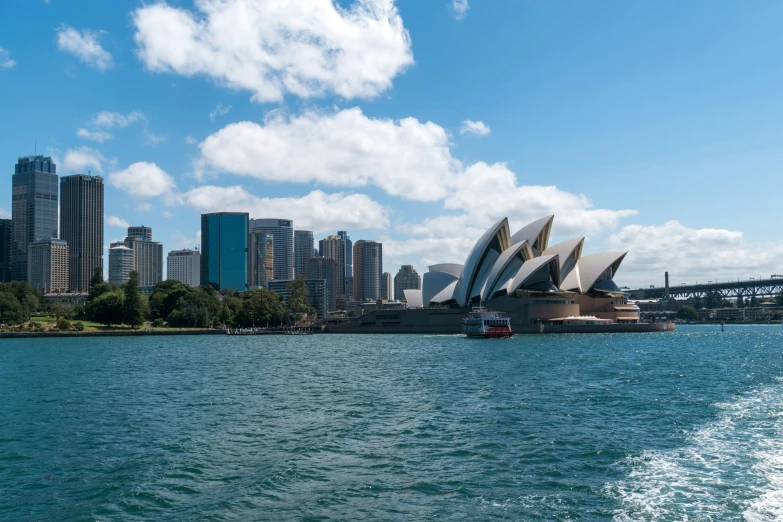 opera house is sitting in the middle of water