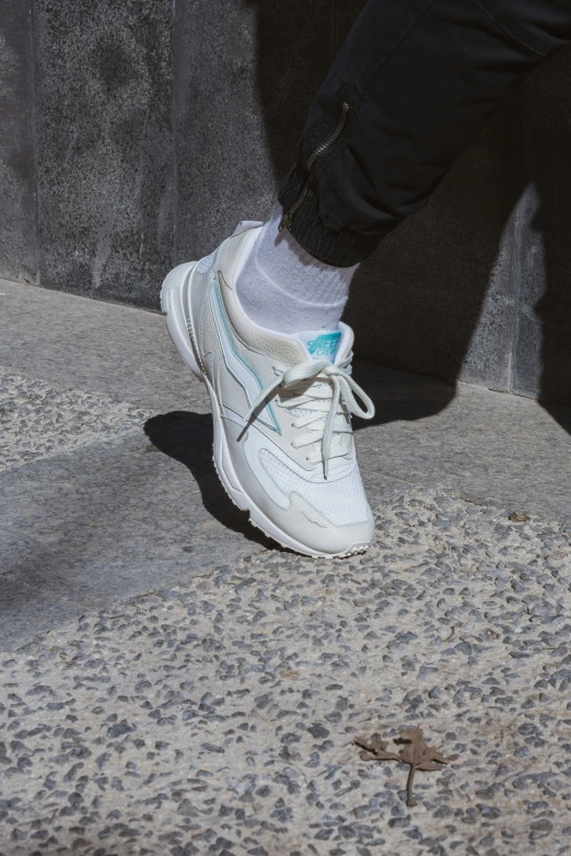 person walking on pavement next to cement wall