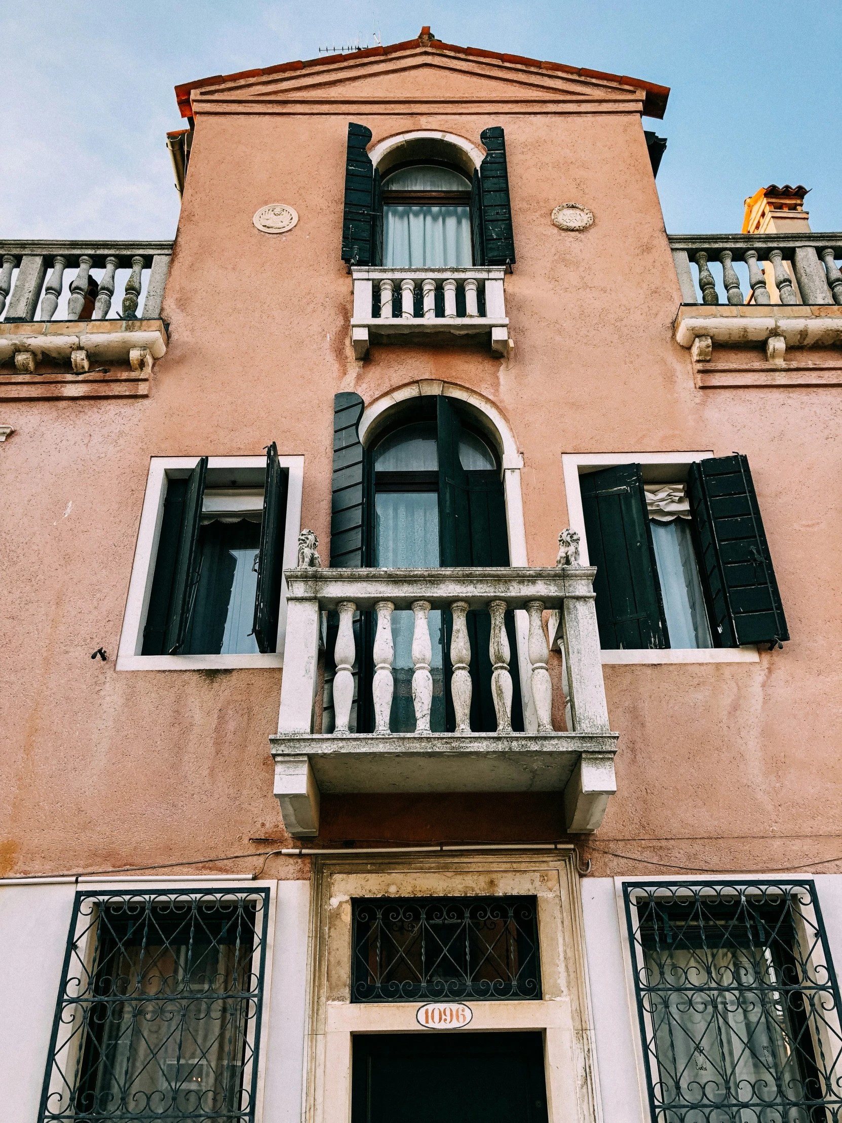 a red building with lots of black shutters and balconies