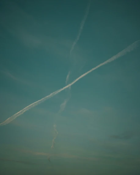 two airplanes are flying in a sky on a cloudy day