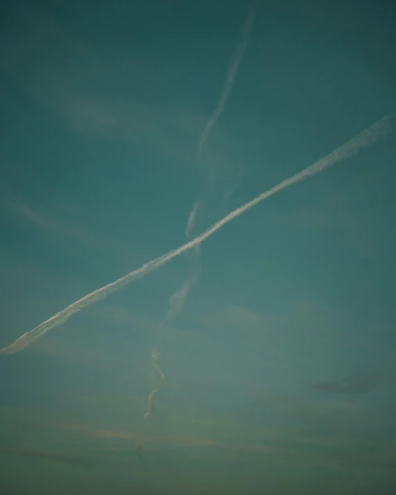 two airplanes are flying in a sky on a cloudy day