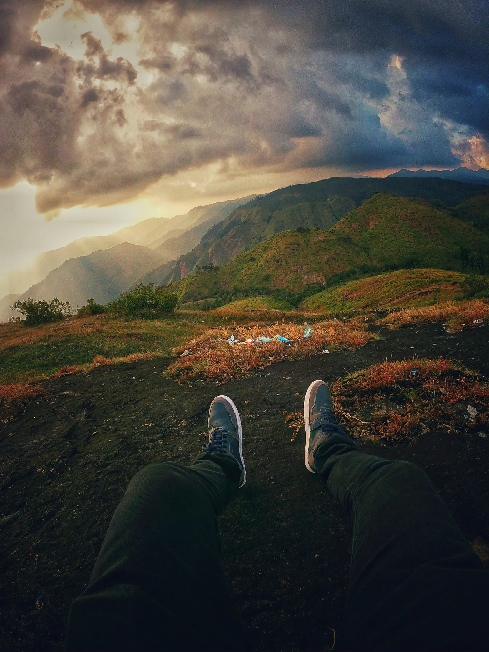 someone standing on top of a field under a cloudy sky