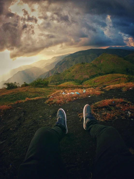 someone standing on top of a field under a cloudy sky