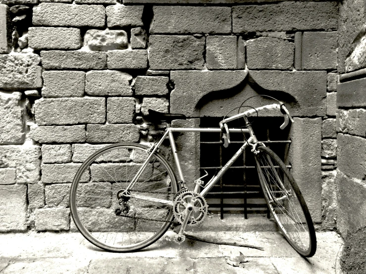 a bike is  to the side of a brick wall