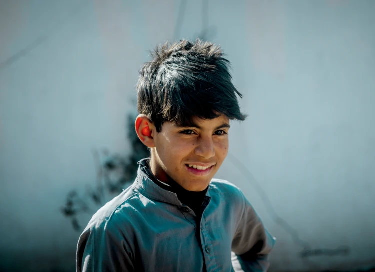 a young man with black hair smiles at the camera