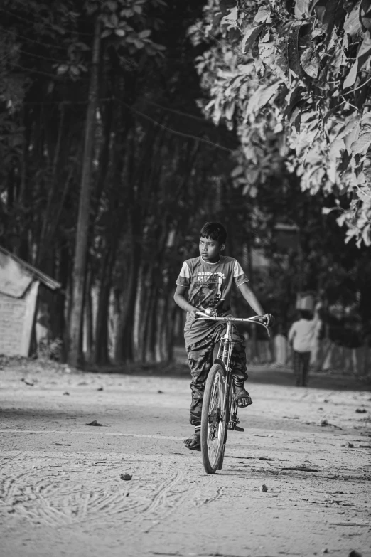 a  on his bicycle riding down a dirt road