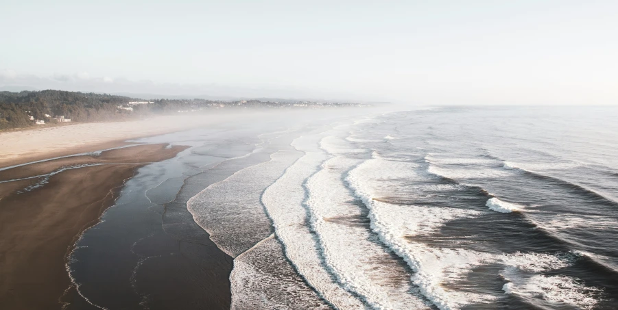 an ocean beach with waves and sandy shore