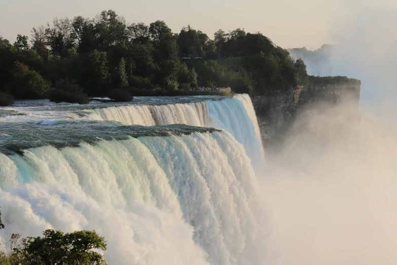 a person is standing near the side of the falls