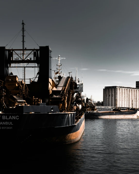 a boat is docked on the water next to a factory