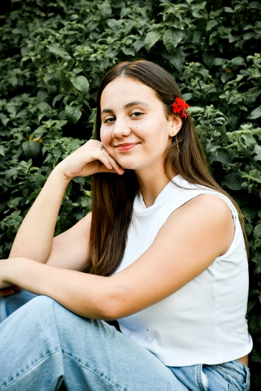 a girl sitting down smiling with her head near her face