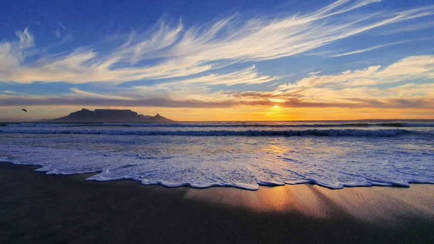 the sun is setting over the ocean with waves