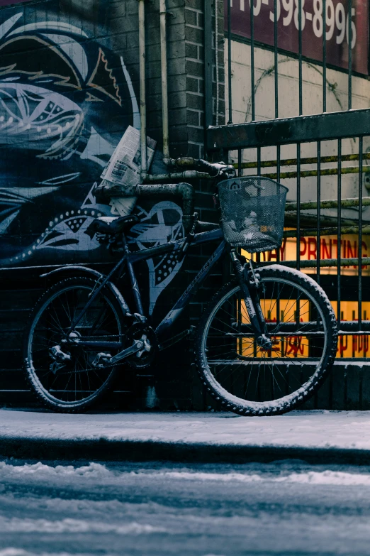 a black and white bicycle sitting next to a graffiti wall