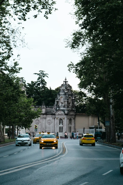 a city street with cars passing by a church