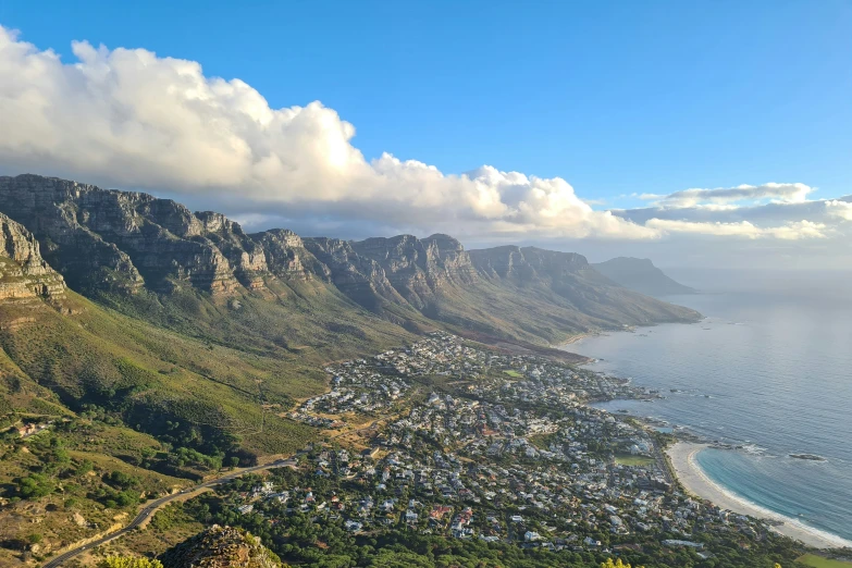 a large mountain and a town next to the ocean