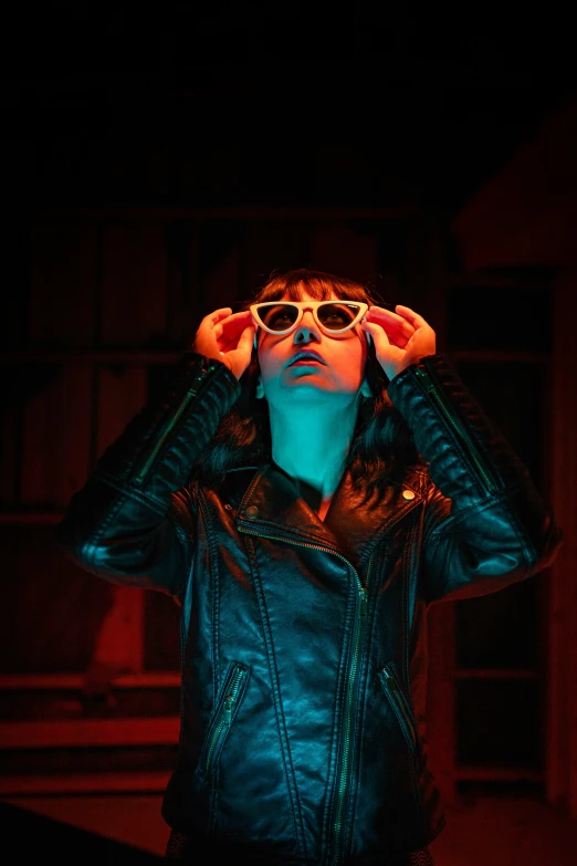 a person wearing sunglasses in the dark holding their head