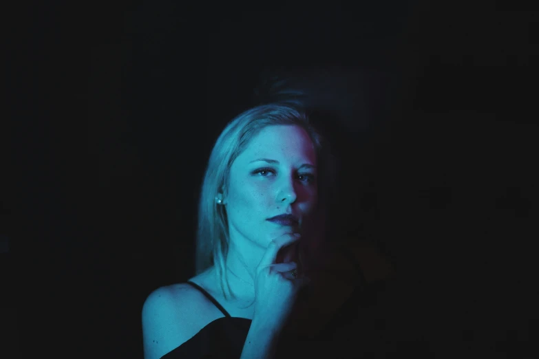 a woman in black shirt next to dark background