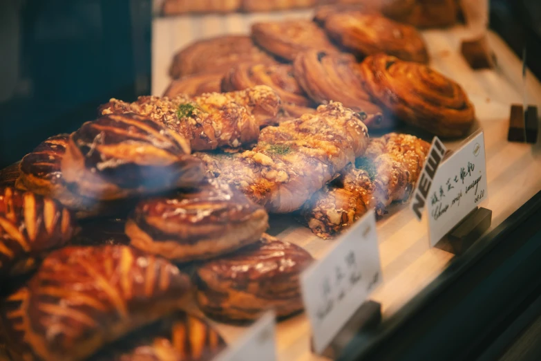 assorted donuts and other pastries on display behind glass