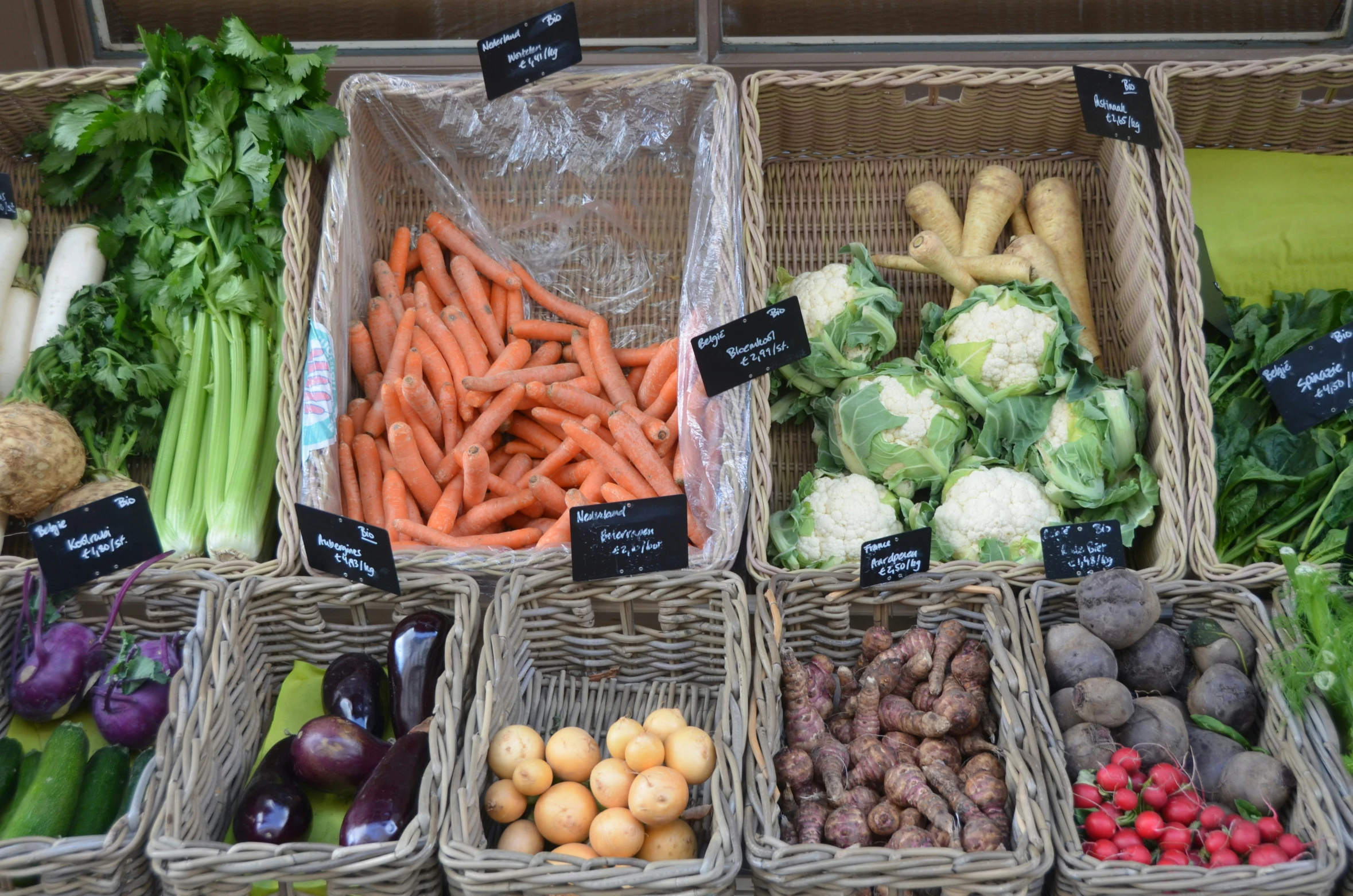 baskets of vegetables are lined up on a table