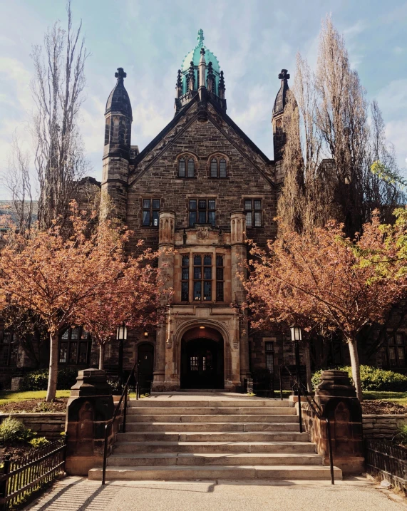 an old building with a steeple on top surrounded by trees