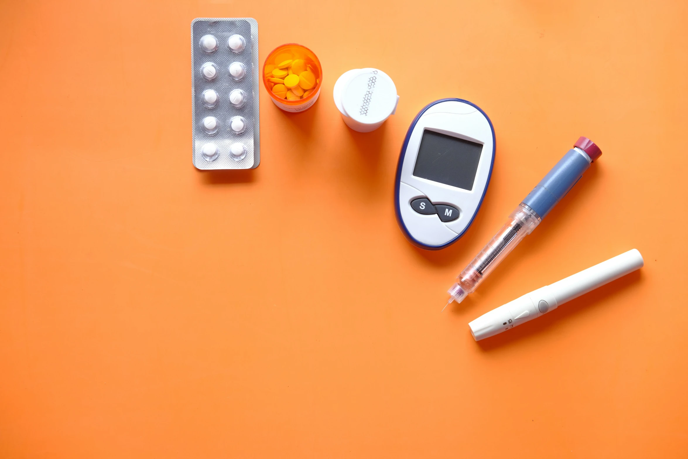 an orange surface has pills and some contraptions