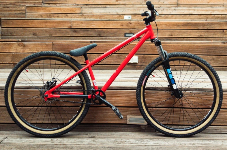 the bicycle is leaning against the wall near a bench