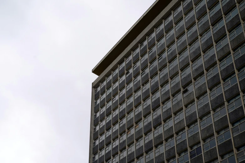 the clock is mounted on the side of a tall building