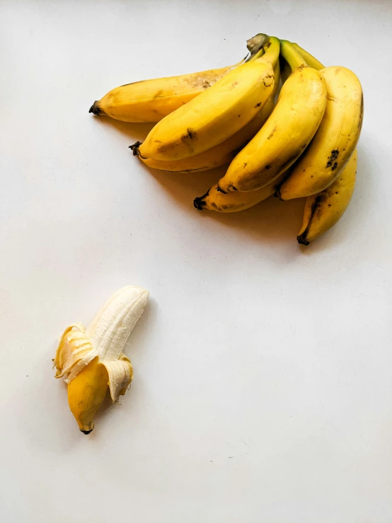 a white board with peeled bananas and one small banana