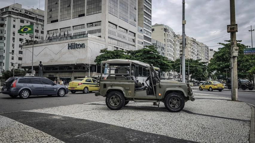 a military jeep is traveling down a busy street
