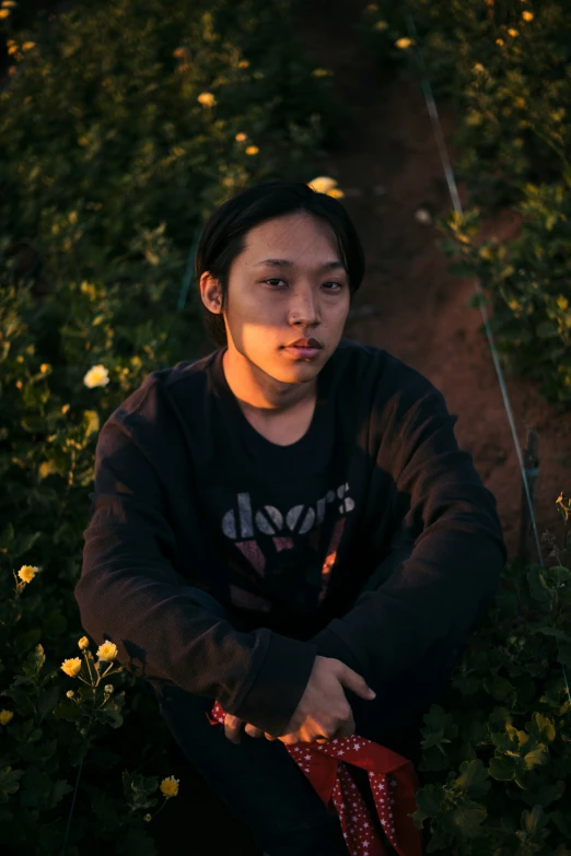 young asian girl sitting in a field of flowers