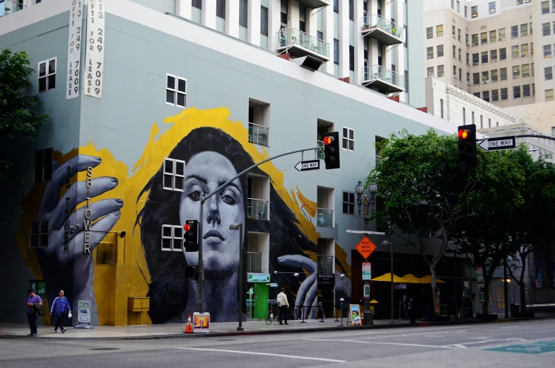 a large painting of a woman is painted on the side of a building