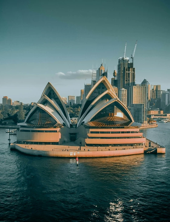 the opera on the water and some buildings in the background