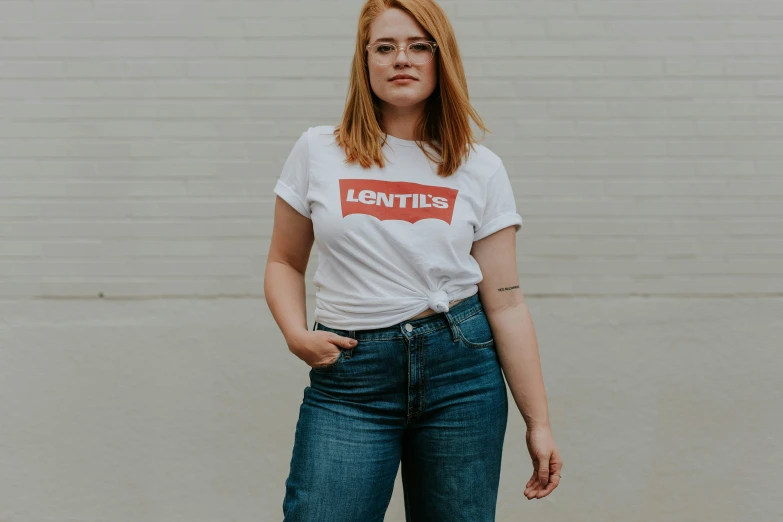 a woman with red hair is wearing jeans and t - shirt