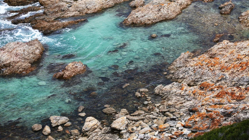 a beach with some rocks and water in the middle