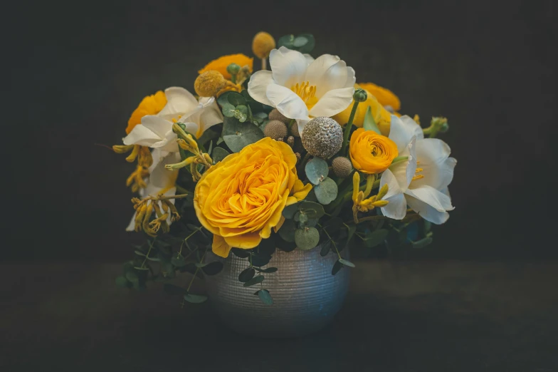 some yellow flowers and white flowers in a vase