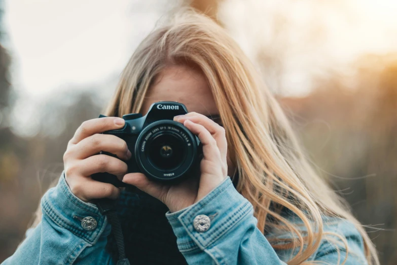 the woman is holding up a camera in her hands