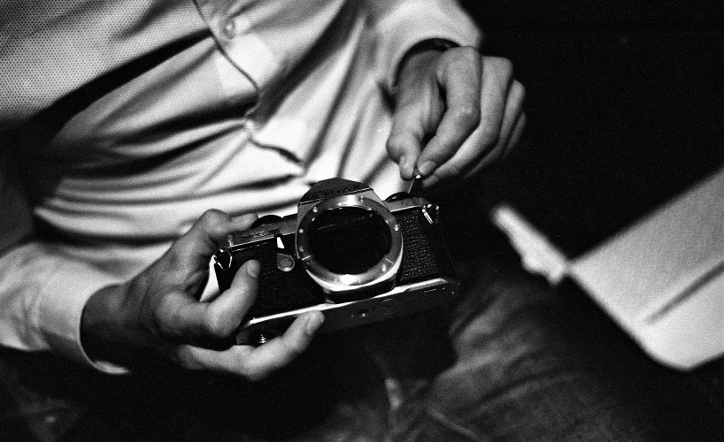 a man holding a camera in a dark room