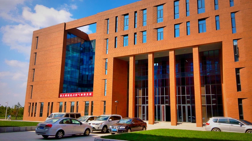 a large building has many cars parked in front