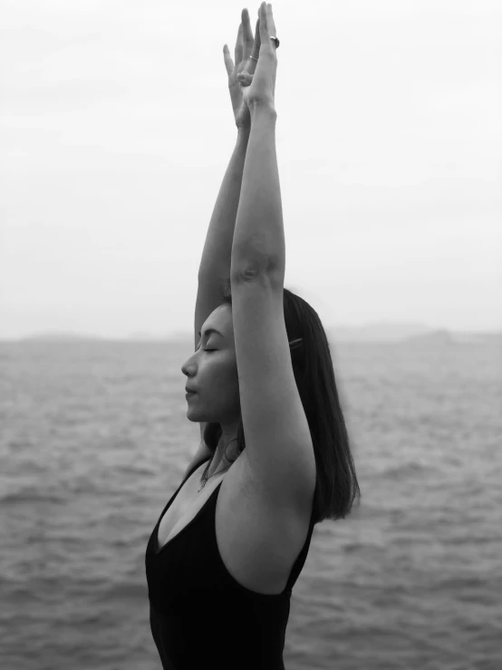 woman doing yoga with her hands on the water