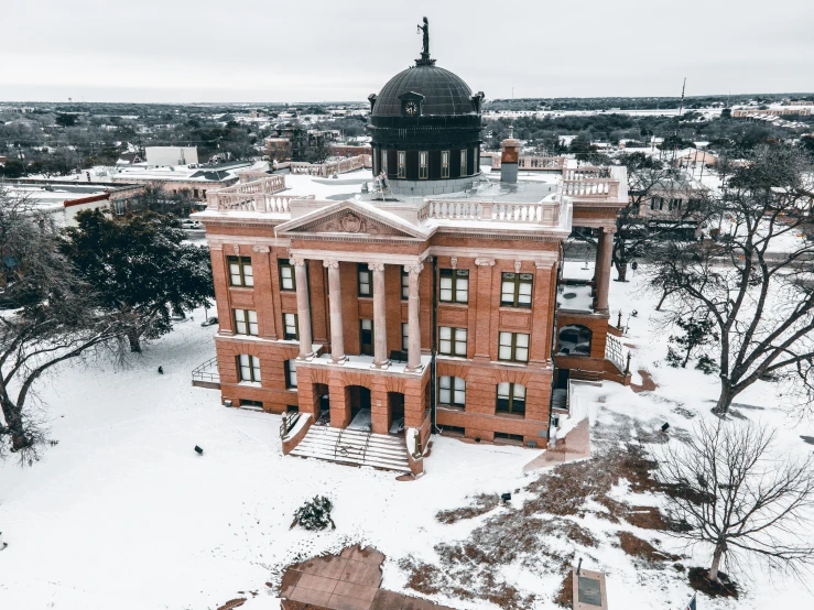 a building sits on a snowy day, with a steeple visible