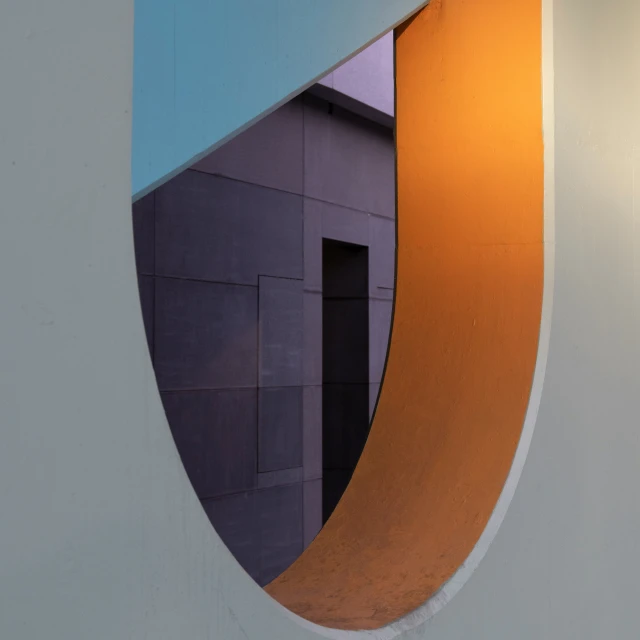 the wall of a building reflected in an abstract circular mirror