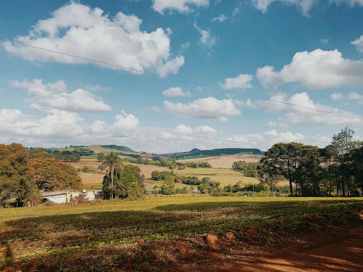 a field with trees and a small house on it