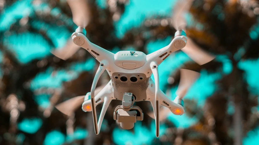 an aerial s of a white toy flying near some trees