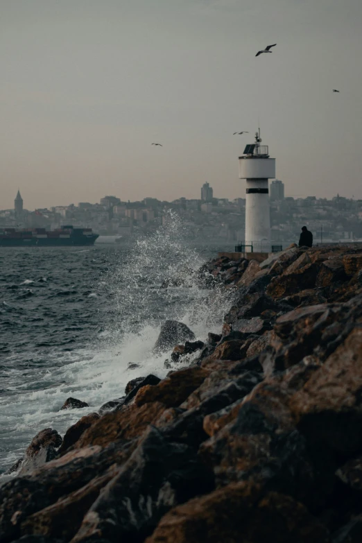 a lighthouse next to the water near buildings