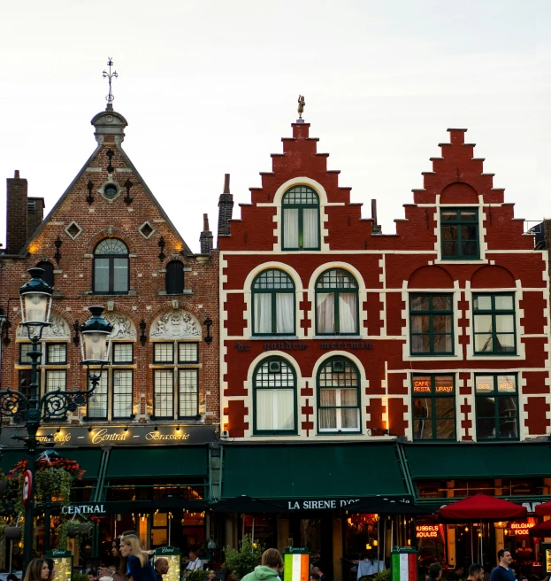 a few red brick buildings in front of an open air market